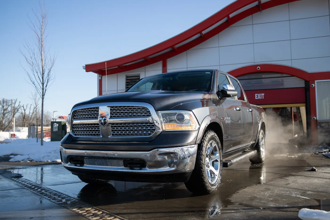 A freshly washed Ram pickup leaving a Kopetsky Auto Wash on a snowy winter day